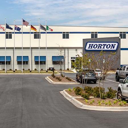 Horton's manufacturing building with signage and flags out front